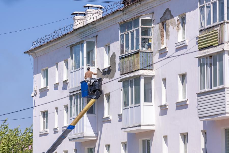 Ouvrier en nacelle devant la façade d'un immeuble